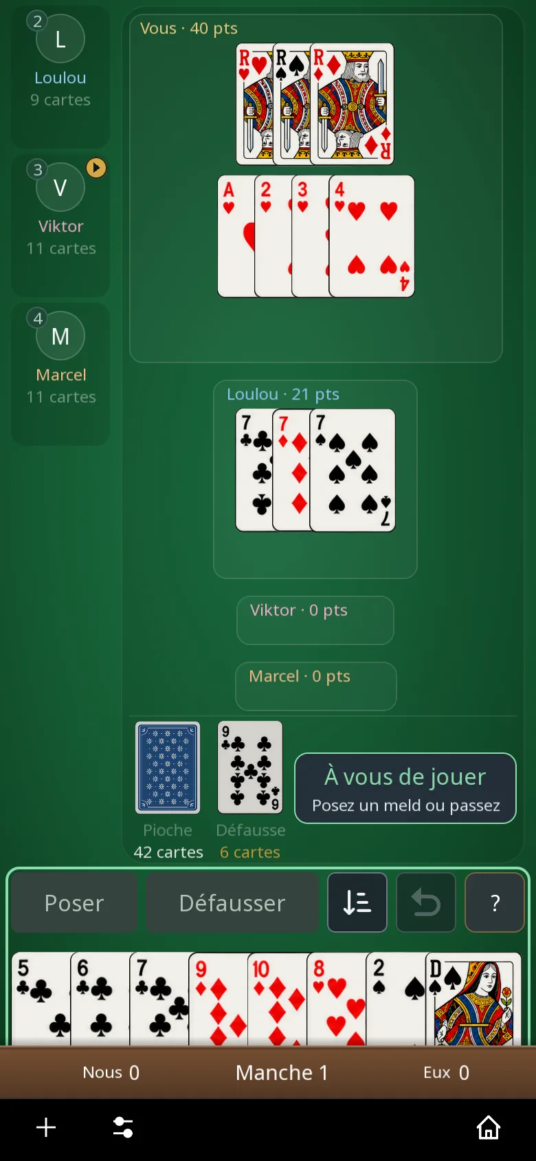 La même partie de Rami en mode sombre : le tapis vert reste le même, la barre de menu du bas passe au noir, combinaisons posées au centre et votre main en bas.